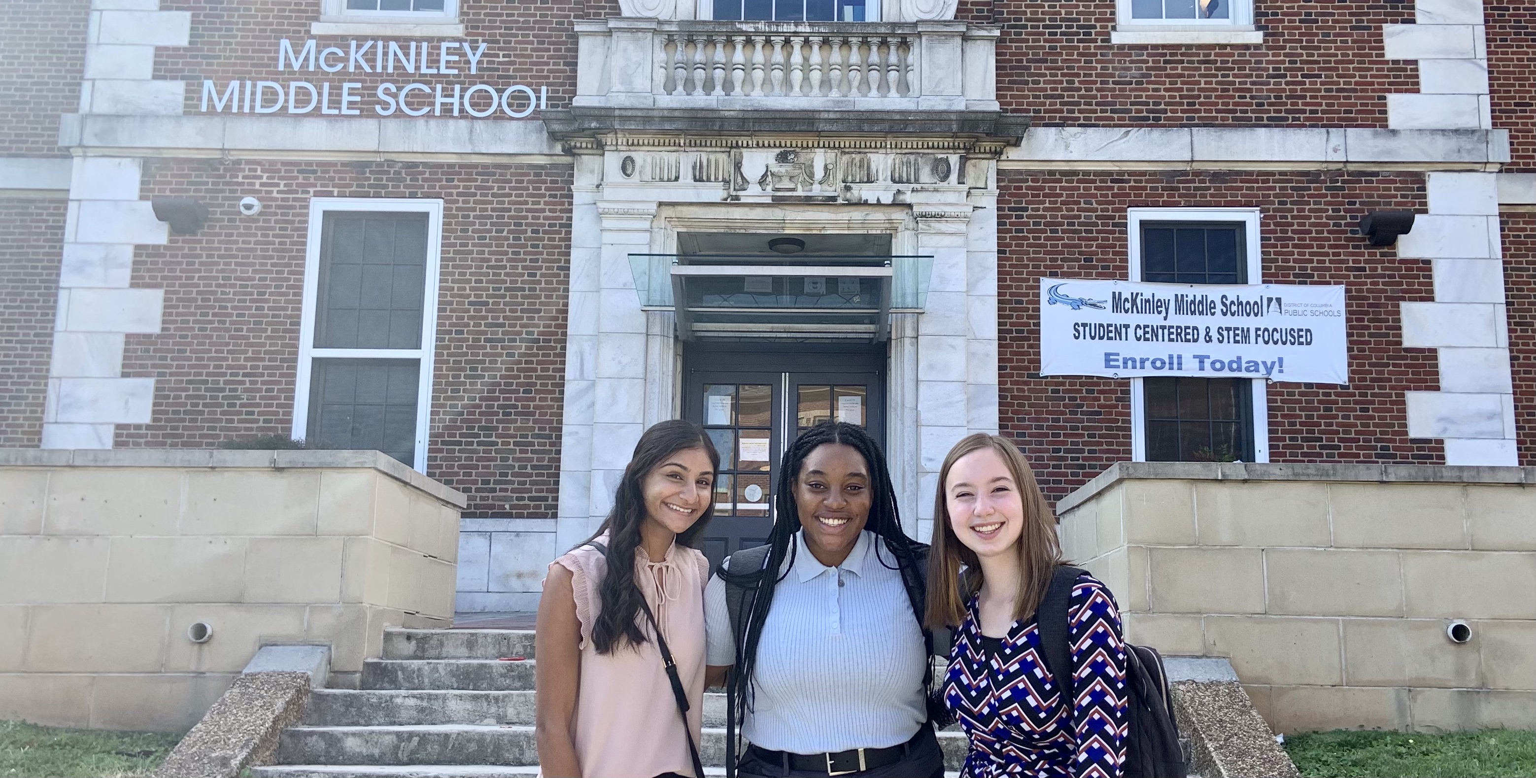 Aneeka Jain, Aaliyah Guzman, and Elise Hedlund pose in front of McKinley Tech Middle School in Northeast D.C. on September 29